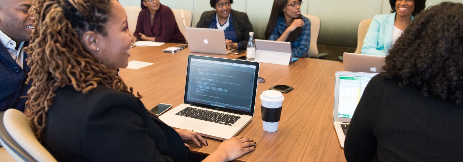 Team collaborating on laptops during AI training